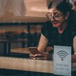 woman connecting to wifi at a coffee shop