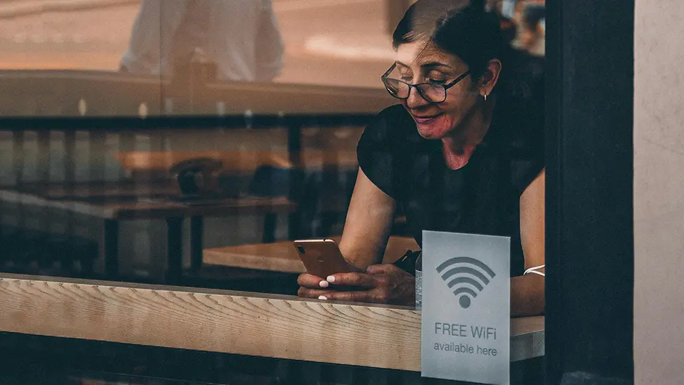 woman connecting to wifi at a coffee shop